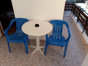 a white table with two blue chairs next to it at Къща за гости Янка in Nesebar