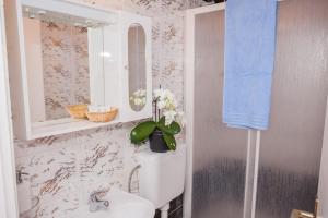 een badkamer met een wastafel en een spiegel bij Hana Home - Apartments Tisno in Tisno
