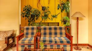 a living room with two chairs and potted plants at Oak Ray Serene Garden Hotel in Kandy