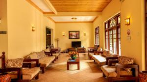 uma grande sala de estar com sofás e uma televisão em Oak Ray Serene Garden Hotel em Kandy