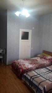 a bedroom with two beds and a white door at gostevoi dom in Zugdidi