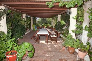 a patio with a table and chairs under a pergola at Villa Zacharo in Skala