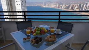 a table with a tray of fruit and drinks on a balcony at Apartamentos Panorámicos Trinisol II in Benidorm