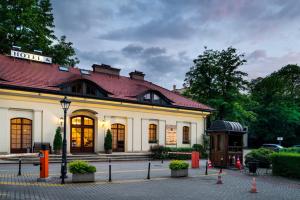 un gran edificio blanco con techo rojo en Hotel Maltański, en Cracovia