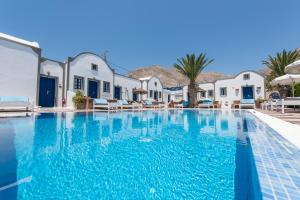 a large swimming pool with a blue and white swimming pool at Anezina Villas in Perissa