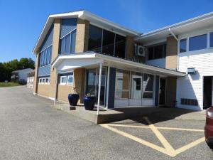 un edificio con due piante in vaso di fronte ad esso di Admiral Digby Inn Restaurant and Cottages a Digby