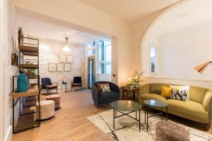 ein Wohnzimmer mit einer grünen Couch und Stühlen in der Unterkunft VEINTIUNO Emblematic Hotels by Airnest in Las Palmas de Gran Canaria