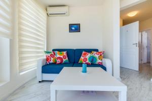 uma sala de estar com um sofá azul e uma mesa branca em Villa White Dove em Golden Sands