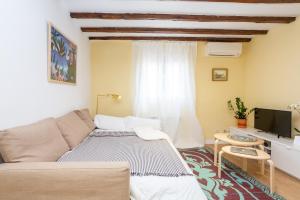 un soggiorno con un divano e una TV di Calidez en Malasaña - Nix a Madrid