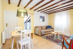 un soggiorno con un tavolo e un divano di Calidez en Malasaña - Nix a Madrid