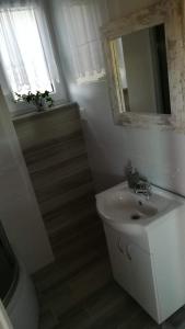 a white bathroom with a sink and a mirror at Niezapominajka Kopalino in Kopalino +29 photos