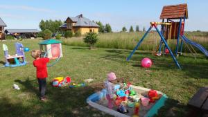 two children playing with toys in a yard at Gaski Na Fali in Gąski