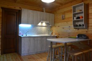 a kitchen with a sink and a counter with stools at Cooper House in Szack