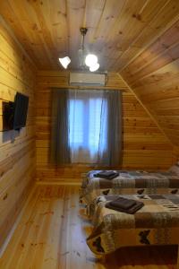 a room with two beds in a log cabin at Cooper House in Szack