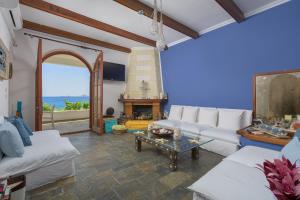 a living room with a white couch and a fireplace at Haraki Sea View Luxury House in Rhodes Town
