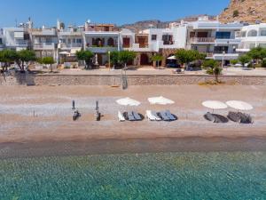 um grupo de cadeiras e guarda-sóis numa praia em Haraki Sea View Luxury House em Rodes