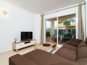 sala de estar con sofá y TV de pantalla plana en Apartment Pinazo by Interhome, en Cumbre del Sol