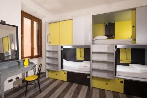 a room with two bunk beds with a desk and a mirror at Free Hostels Roma in Rome
