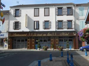 un grande edificio bianco con un cartello per un negozio di le tout va bien a Valence-dʼAgen