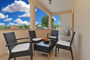 patio z krzesłami i stołem z widokiem w obiekcie Apartment Dvori with pool w mieście Kaštelir