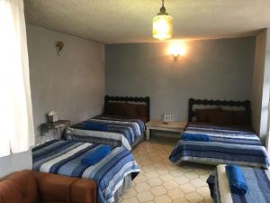 ein Wohnzimmer mit 2 Betten und einem Sofa in der Unterkunft Casa Antaña in San Miguel de Allende