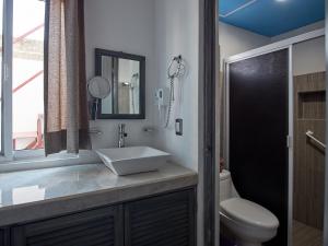 a bathroom with a sink and a toilet and a mirror at Hotel Tabasco Rio in Río Lagartos