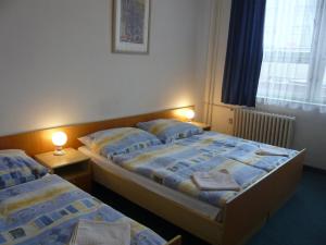 dwa łóżka w małym pokoju z dwoma lampami w obiekcie Hotel Hasa w Pradze