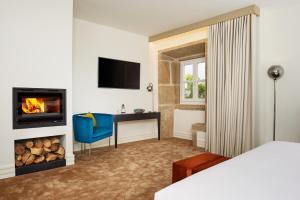 ein Hotelzimmer mit Kamin und ein Zimmer mit Bett in der Unterkunft Convento do Seixo Boutique Hotel & Spa in Fundão