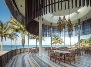 a restaurant on the beach with tables and chairs at Ban Saithong Beach Resort in Bang Saphan Noi