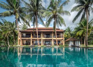 a resort with palm trees in front of a swimming pool at Ban Saithong Beach Resort in Bang Saphan Noi