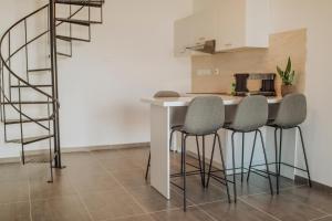 a kitchen with a table with four chairs and a spiral staircase at River View Boutique Apts in Ayia Napa