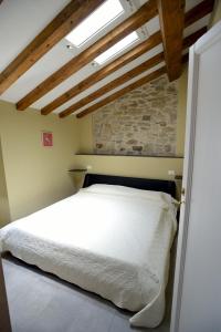 VasiaにあるChalet in Liguriaの白いベッドとレンガの壁が備わるベッドルーム1室が備わります。