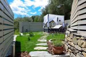 un jardín con una tienda y una pared de piedra en Chalet in Liguria, en Vasia