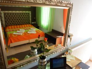 einen Spiegel auf einem Schreibtisch mit einem Bett in einem Zimmer in der Unterkunft Hotel White Rose Beach in Olympiakí Aktí