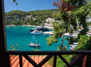 a boat docked at a pier next to a lush green hillside at Liadromia Hotel in Patitiri