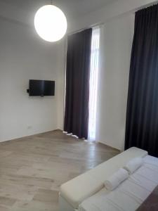 un salon avec un canapé blanc et une télévision dans l'établissement Villa Roan, à Bar