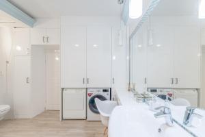 baño blanco con lavamanos y lavadora en Apartment in Andrássy Avenue, en Budapest