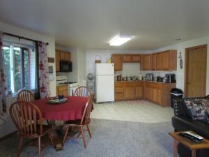 a kitchen and living room with a table and a refrigerator at Peaceful 3 bdrm Alaskan getaway in Wasilla
