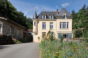 una casa con un jardín de flores delante de ella en Le Berthoir, en Pélussin