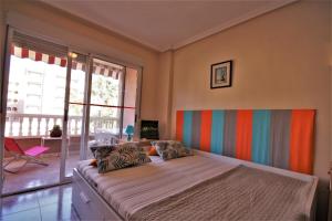 Dormitorio con cama grande y cabecero colorido en Playa Lisa Studio, en Santa Pola