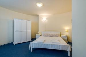 a bedroom with a large bed and a white cabinet at Villa White Dove in Golden Sands