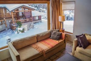 een woonkamer met een bank voor een raam bij Galileo Boutique Hotel in Bariloche