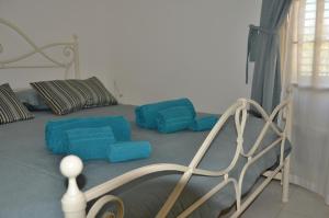 a bedroom with a bed with blue pillows at Guest House Adele in Marina di Ragusa