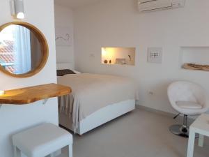 1 dormitorio con cama, espejo y silla en Alto Rooms and Apartments, en Dubrovnik