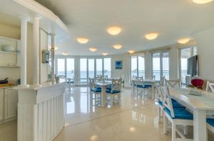 a dining room with tables and chairs and windows at Villa White Dove in Golden Sands