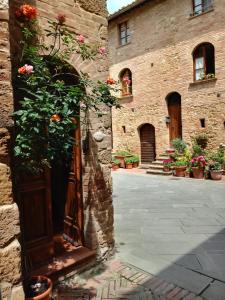 ピエンツァにあるSmall lovely home in Pienzaの植物の扉付きの石造りの建物