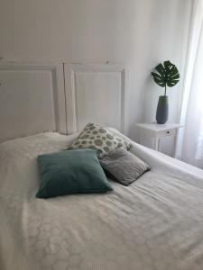 - un lit blanc avec deux oreillers et une plante en pot dans l'établissement Charmante 3 Zimmer, Stadtwohnung, à Menton
