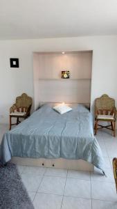 a bed in a room with two chairs at Les Fontaines Saint Leonard in Honfleur