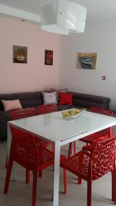 ein Wohnzimmer mit einem weißen Tisch und roten Stühlen in der Unterkunft Diva Star Bol in Bol