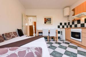 ein Hotelzimmer mit einem Bett und einem Tisch sowie einer Küche in der Unterkunft Apartments Manuela in Zadar